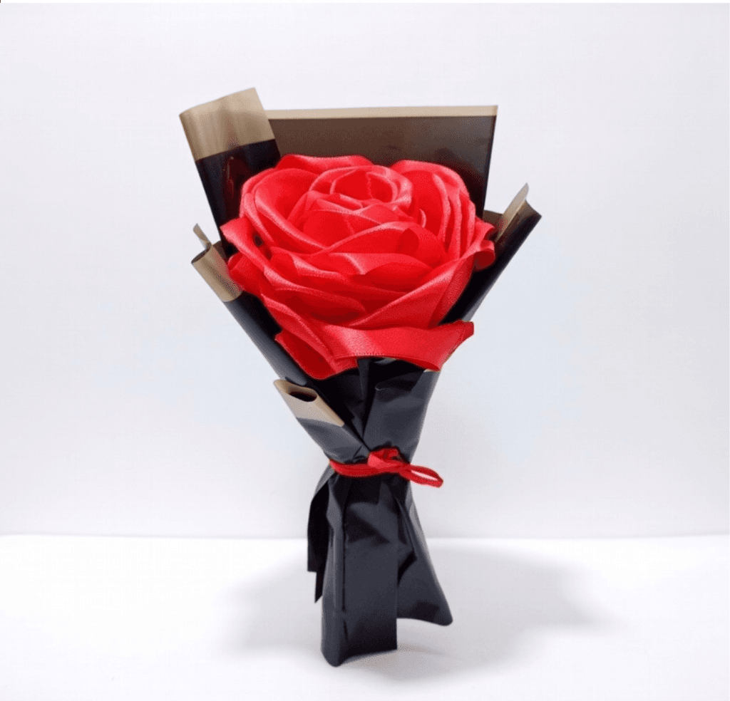 Large single red satin rose wrapped in black paper with gold trim